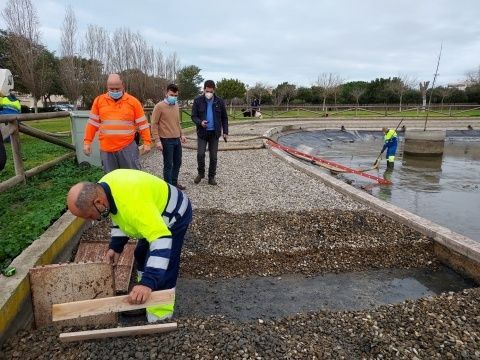 Operarios limpiando la laguna y colocando rampas