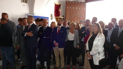 Devotos en la capilla viendo el retranqueo