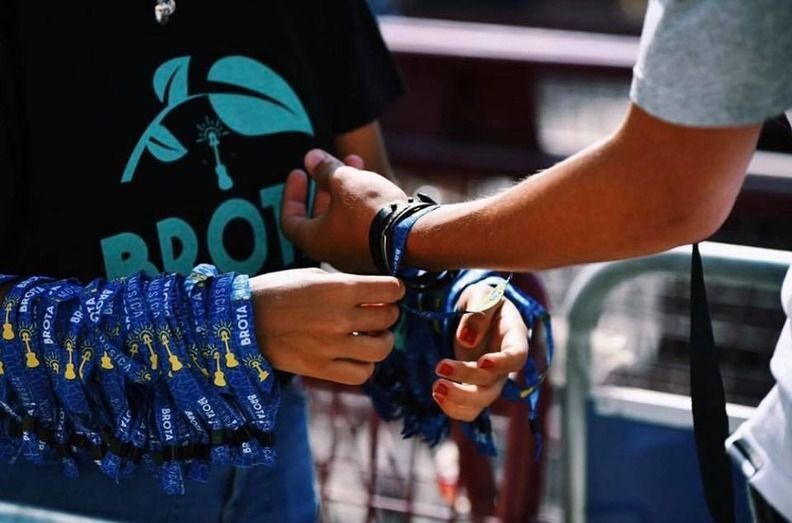 Un joven recibe su pulsera para acceder al festival