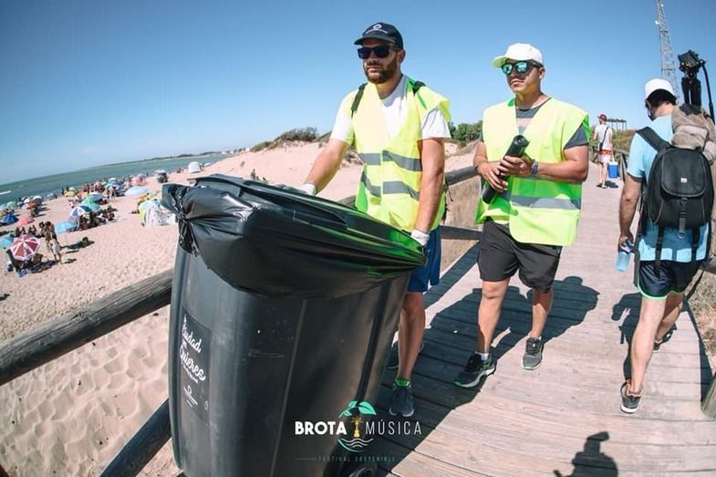 Dos colaboradores transportan una papelera