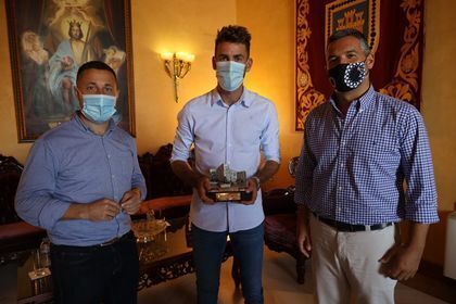 José Mari posa con su distinción y los dos representantes municipales