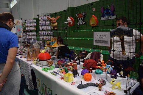 Uno de los asistentes al salón mirando uno de los puestos de figuras y merchandansing con temática 'Pokemon'