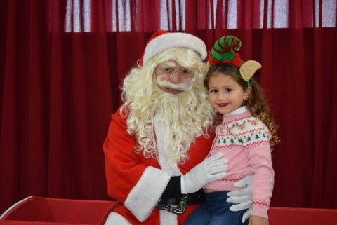 Una niña tomándose una foto con Papá Noel